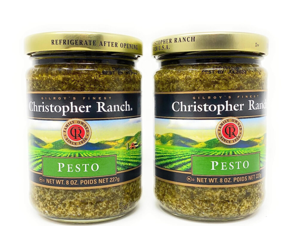 Christopher Ranch Pesto sauce in a jar with a gold lid and white background.