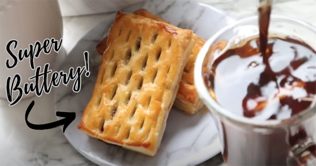 Nutella Walnut Puff Pastry Dessert on a white marble-looking plate with a glass cup of tea a white canister and a green plant in a white vase on a white countertop.