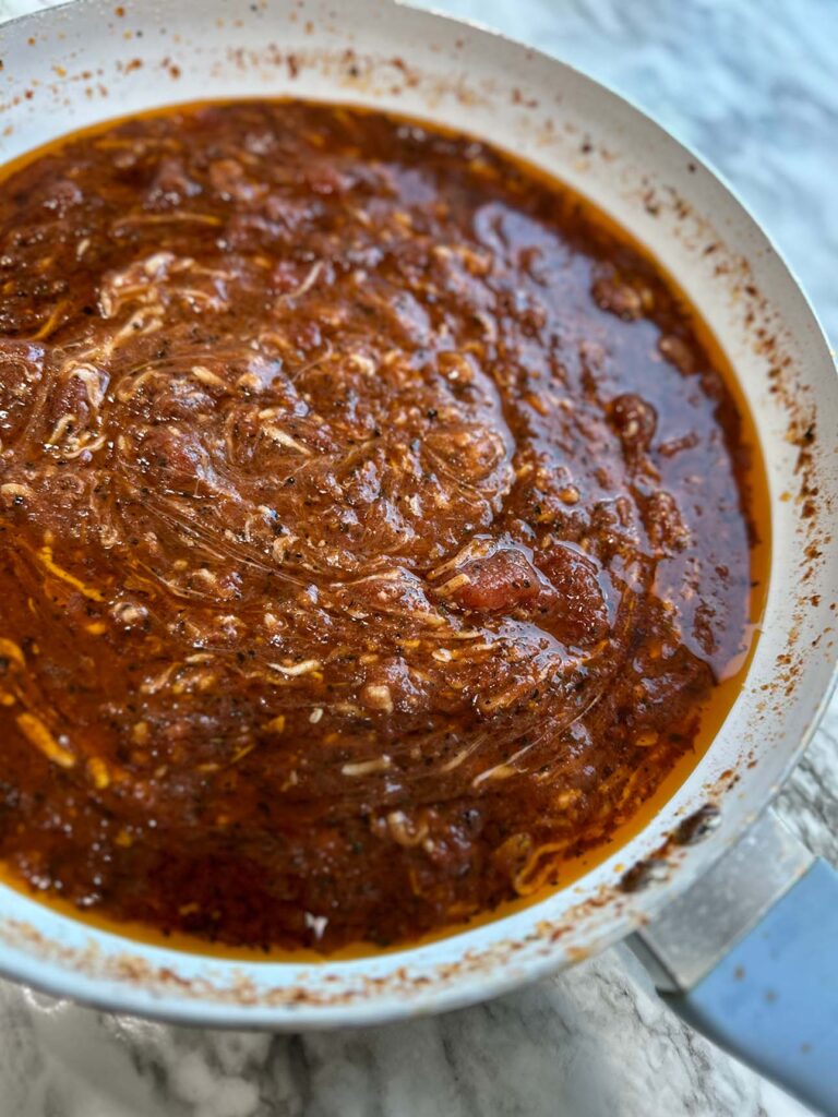 Cajun Chicken Meatball Pasta Sauce in a white sauce pan on a white countertop.