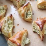 Buttery Cheese Puff Pastry Bites - Borek on a baking pan with a rubber mat baking sheet.