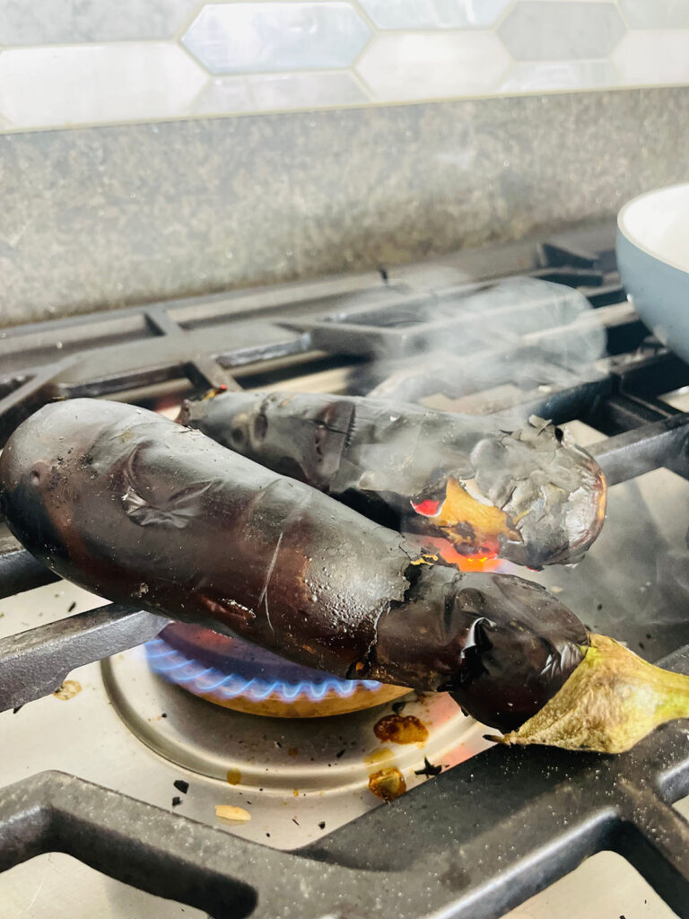 Babaganoush Recipe eggplant roasting on a stove on an open fire 