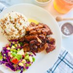 Honey Mustard Chicken with Pinapple Salad w/ Orzo Rice on a white plate