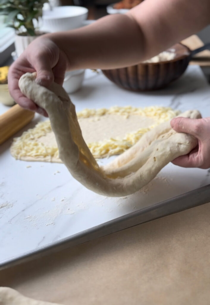 Flatbreads - lift dough and flour surface with hands and lifting into baking sheet.