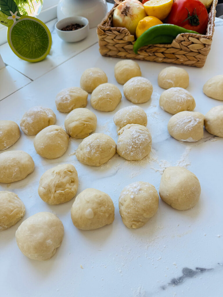 Mediterranean Meat & Cheese Savory Rolls- Dough balls on a white countertop