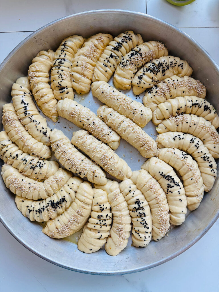 Mediterranean Meat & Cheese Savory Rolls - uncooked rolls with sesame seeds ontop ready to bake