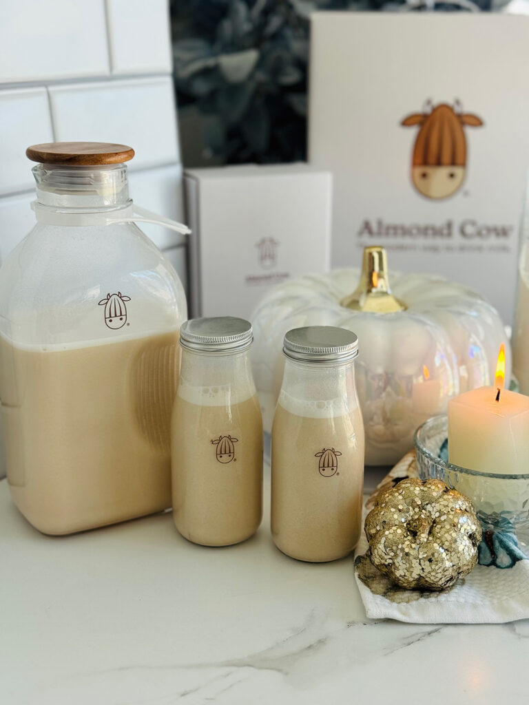 Buttery Pecan Upside Down Cake - Almond Cow - Almond Cow milk in bottles with lit candle and almond cow packaging in background