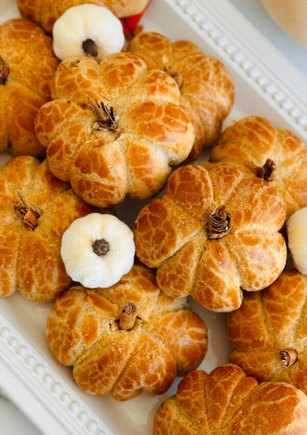 Pumpkin Pie Nazook - A Fall Twist on an Armenian Classic Recipe - Pumpkin shapped Nazook / Gata on a white serving platter with white artificial pumpkins as docor.