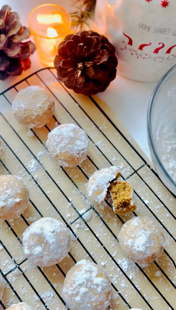 Spiced Holiday Pryaniki Cookies - Ginger Cookies- frosted cookies on a black cooling rack with parchment paper underneath with a broken cookie on the top right.