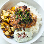 Aleppo Chicken Veggie Rice Bowl with Aleppo Chili Oil in white round platter
