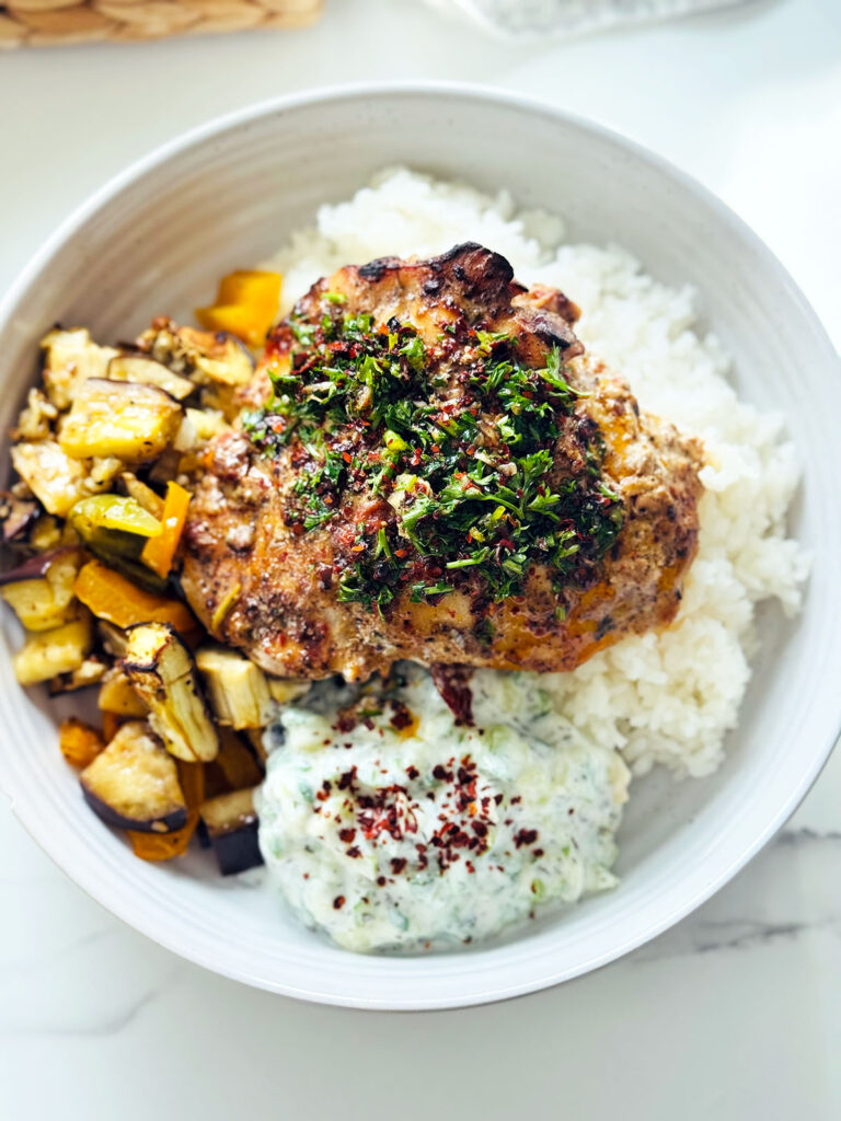 Aleppo Chicken Veggie Rice Bowl with Aleppo Chili Oil in white round platter